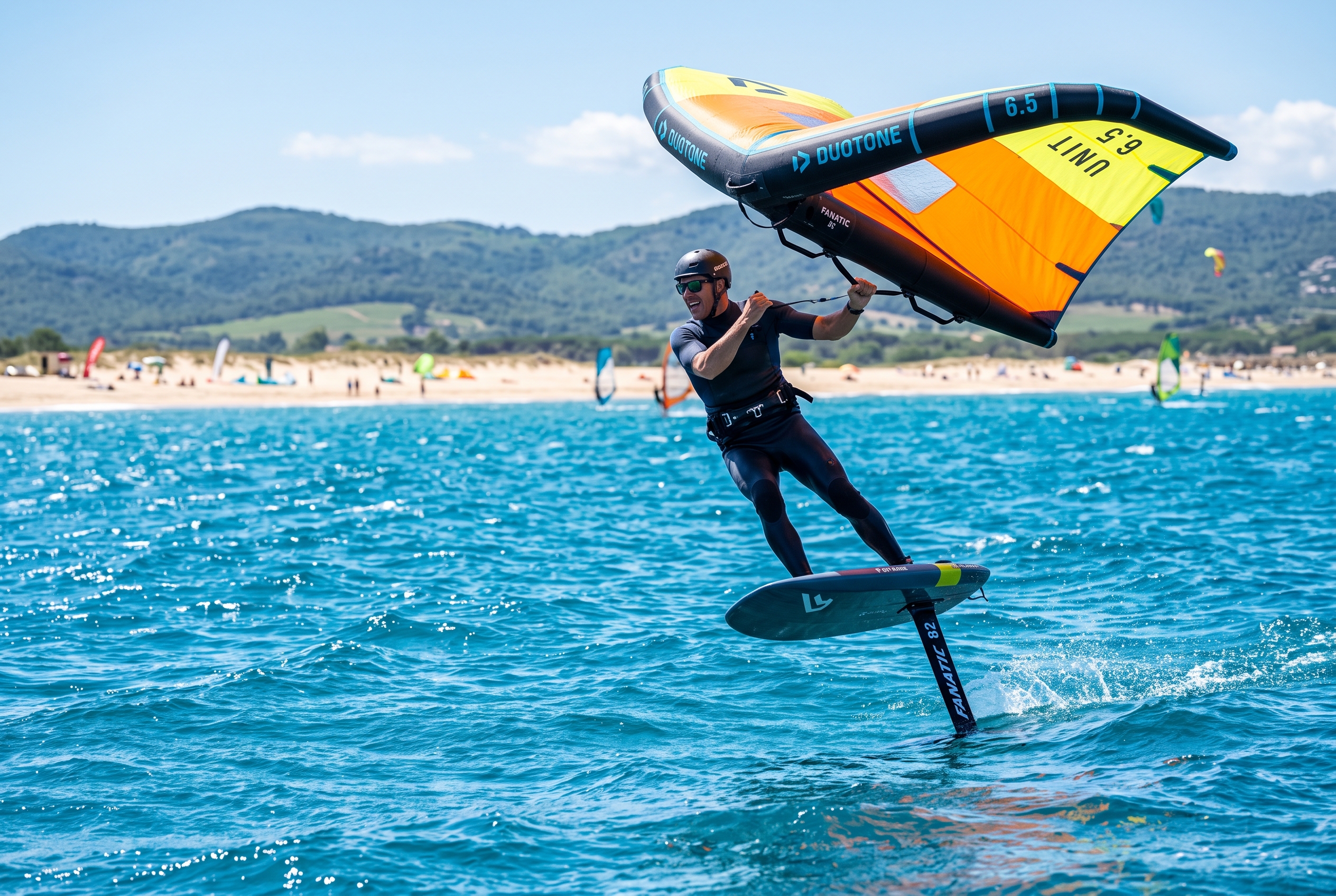 Wing foiler on a hydrofoil holding a wing off the sandy Sant Pere Pescador beach in the Bay of Roses, Costa Brava