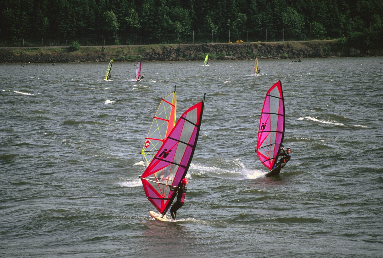 Windsurfers on wind-whipped water in the Columbia River Gorge at Hood River
